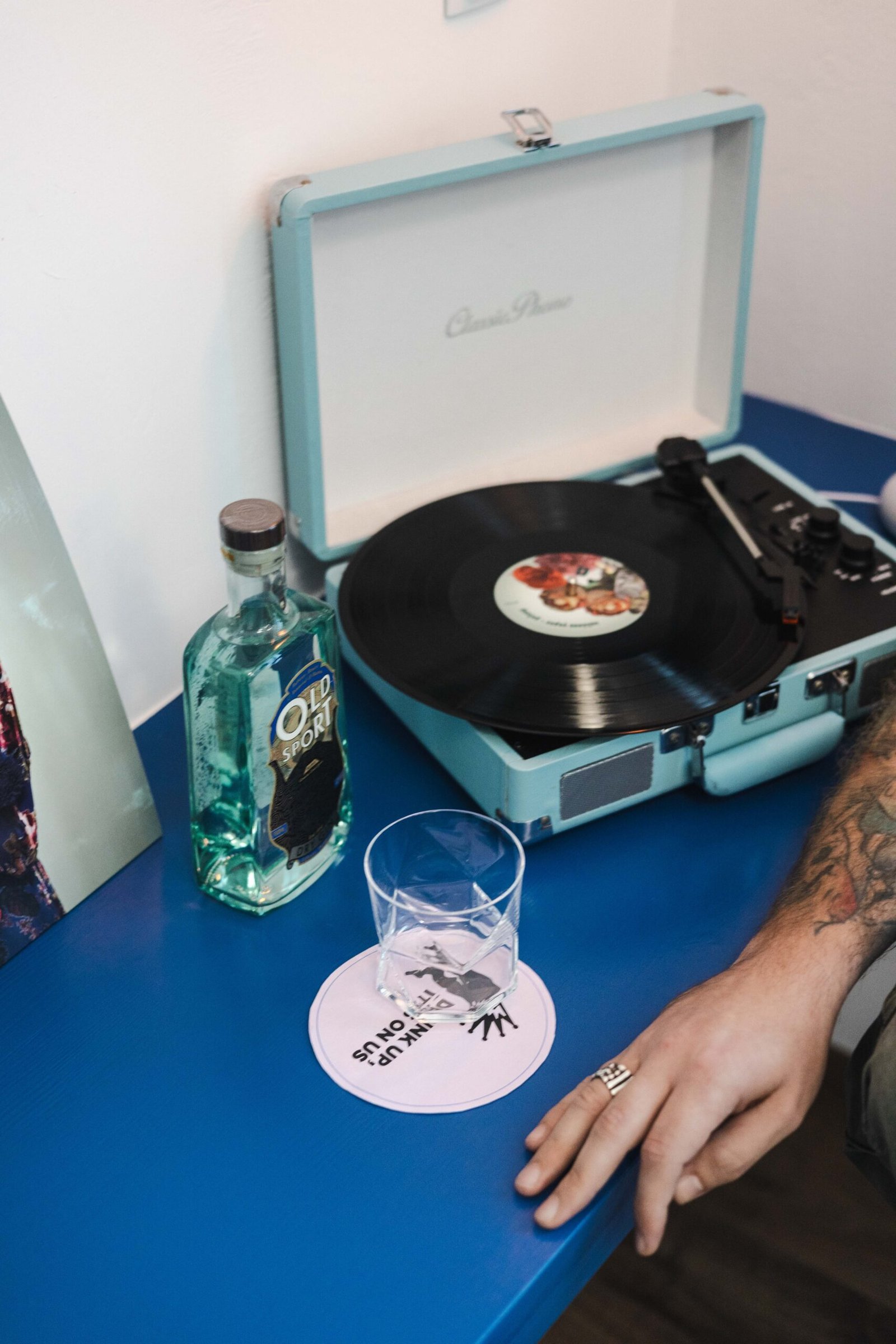 a vinyl player with a bottle of gin