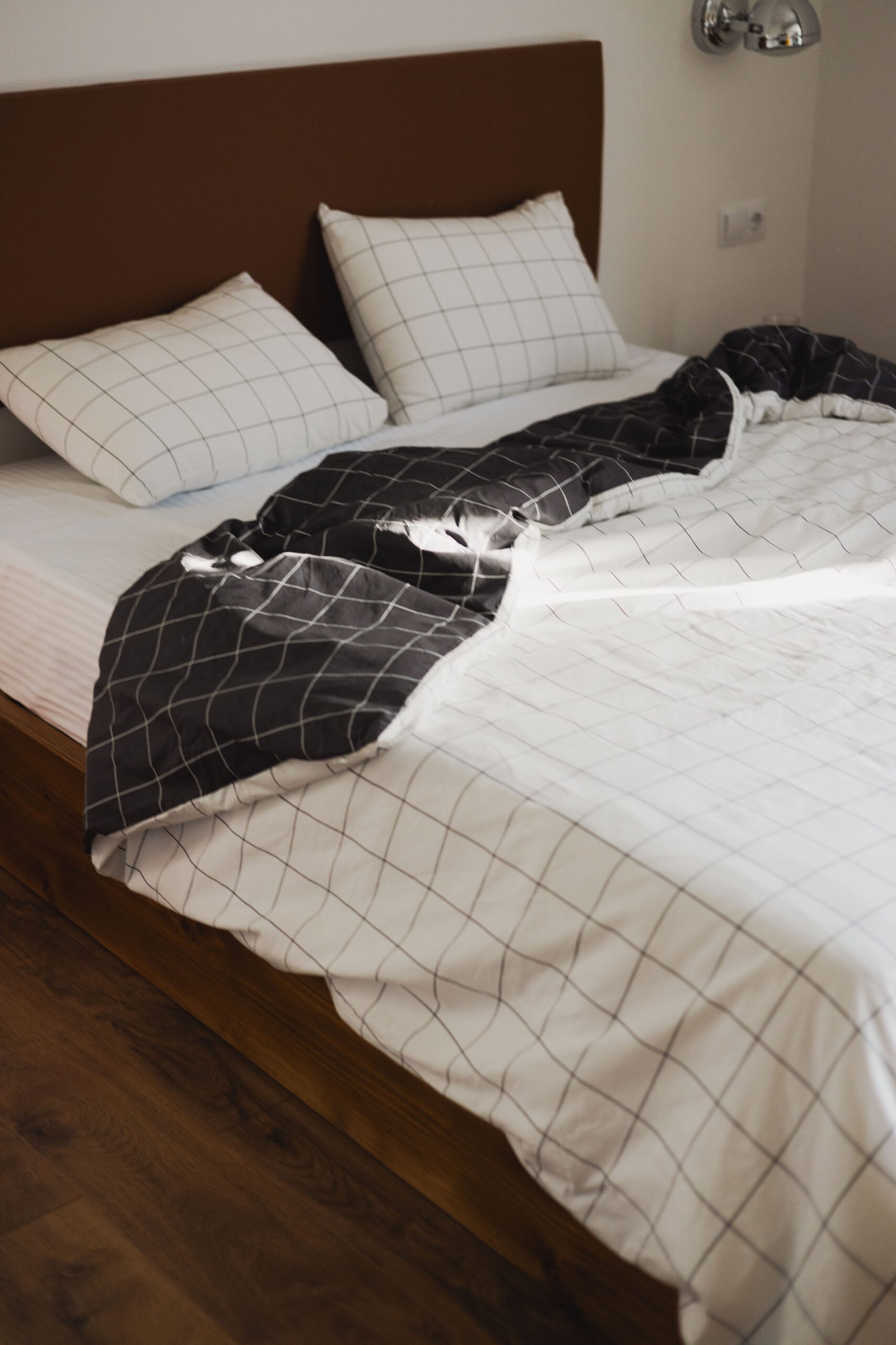 black and white bedsheets and linen of the wooden bed at Baroness 3